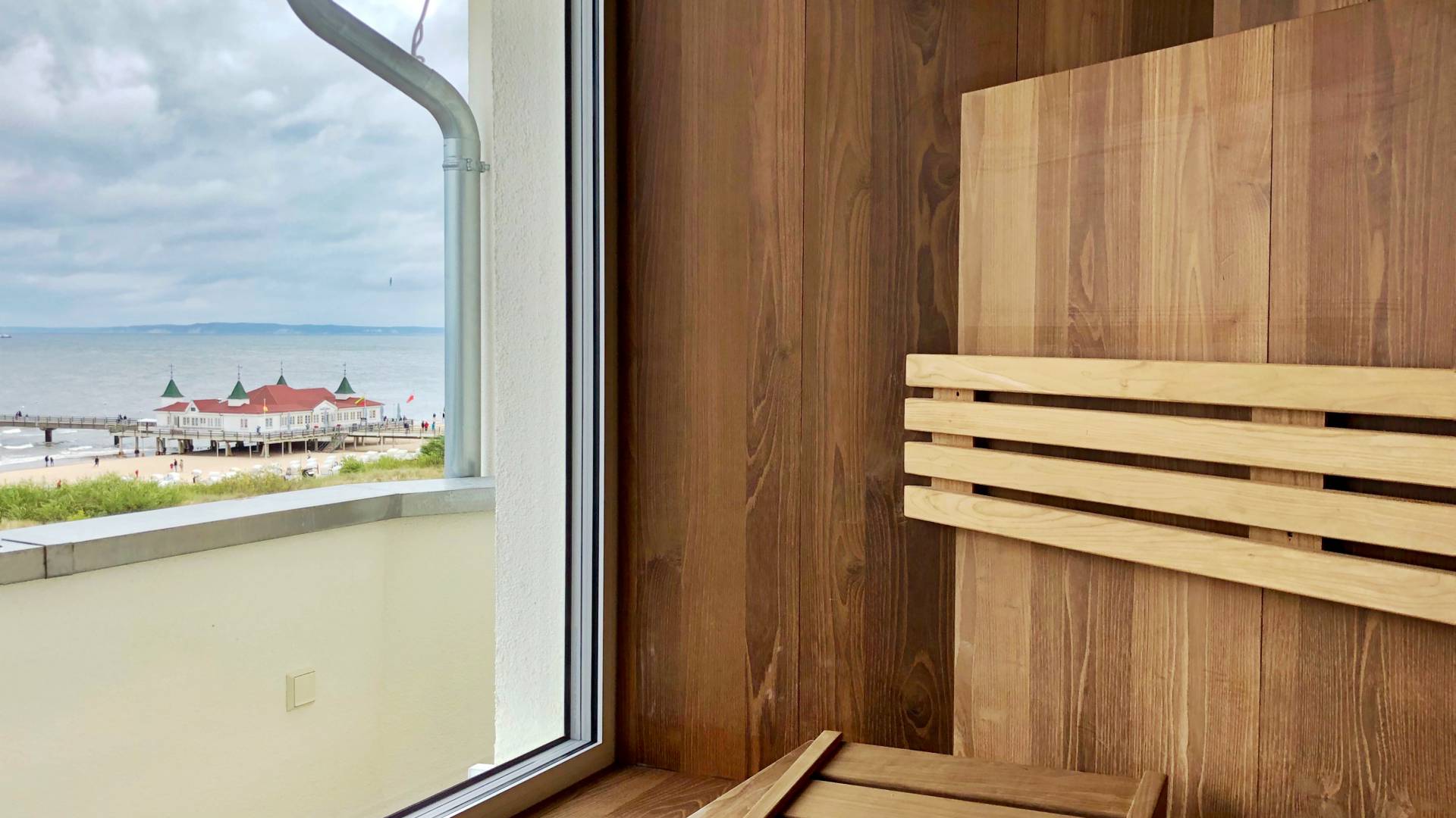 Panorama-Sauna im Das Ahlbeck Hotel & Spa mit Blick auf die Ostsee und die Seebrücke Ahlbeck durch das Fenster