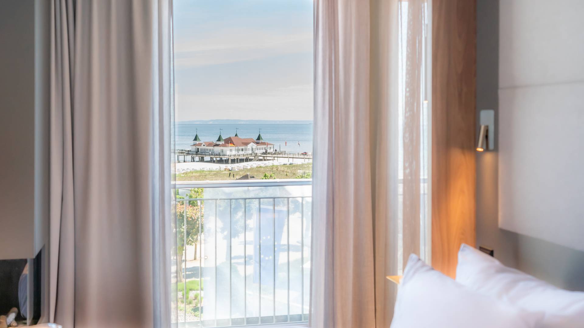 Blick aus einem Hotelzimmer des Das Ahlbeck Hotel & Spa auf die Promenade, den Ostseestrand und die Seebrücke Ahlbeck