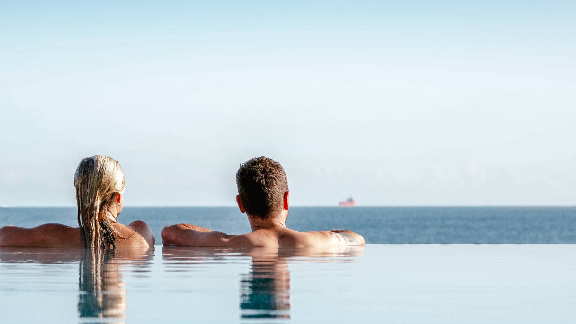 Paar entspannt im Infinity-Pool des Das Ahlbeck Hotel & Spa mit freiem Blick auf die Ostsee.