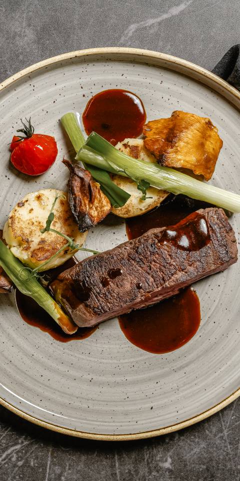 Sous-vide gegarte Hirschhüfte im Restaurant Düne 48, angerichtet mit Gemüse, Kartoffeln auf einem modernen Teller